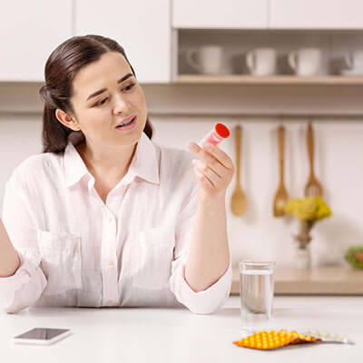 woman looking at prescription bottle 